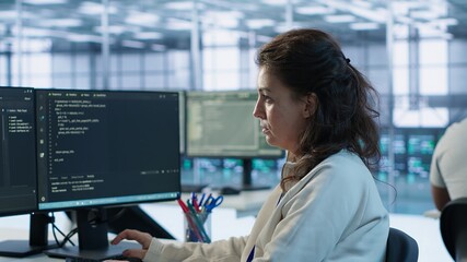 Portrait of smiling technician programming in AI data center used for machine learning training....