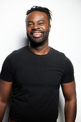 Portrait of a confident Black man with well-groomed beard wearing a denim shirt against a white background