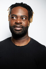 Portrait of a confident Black man with well-groomed beard wearing a denim shirt against a white background