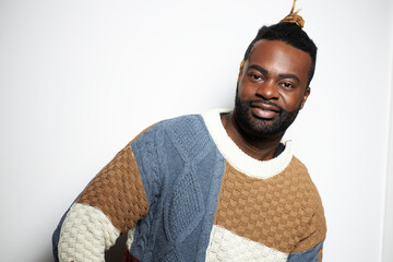 Portrait of a confident Black man with well-groomed beard wearing a denim shirt against a white background