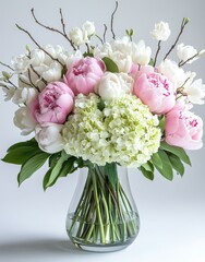 Obraz premium Elegant Floral Arrangement with Pink Peonies, White Tulips, and Green Hydrangeas in a Clear Glass Vase for Home Decor Inspiration