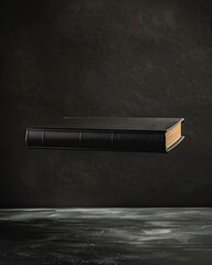 Black hardcover book floating on dark background