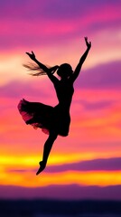 Silhouette of a dancer performing against a vibrant sunset sky
