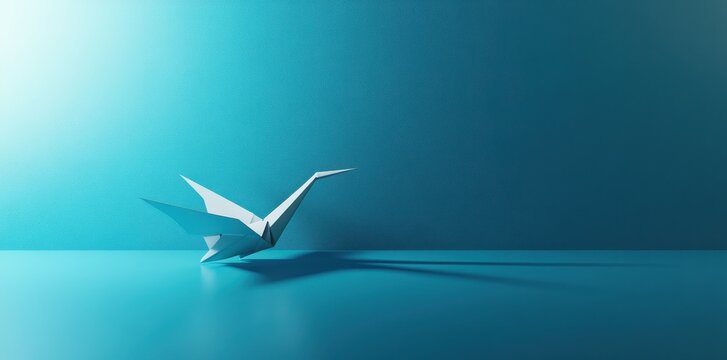 A white paper origami crane resting on a reflective teal surface