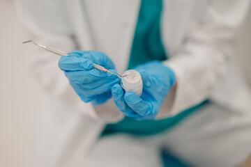 Dentist picking up dental filling material with a tool