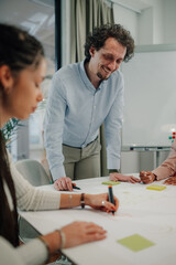 Fototapeta premium Manager smiling and supervising employees working on project