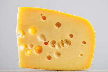 maasdam cheese on grey background, close-up view