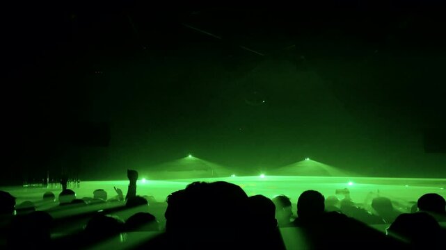 gente bailando en un club nocturno con espect&aacute;culo de laser