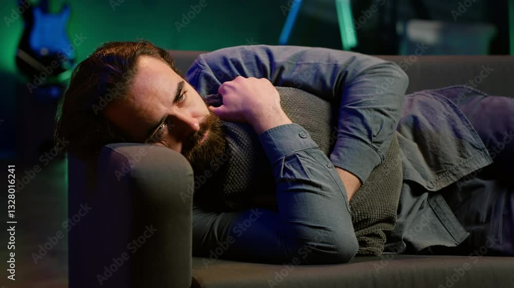 Poster man laying down hugging pillow watching tv, heartbroken by upsetting movie plot. sad viewer lounged 