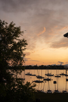 A breathtaking sunset over Lake Bde Maka Ska in Minneapolis, reflecting vibrant colors on the water.