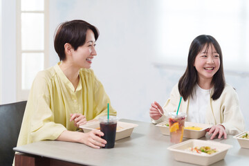 家でデリバリーの弁当を食べる家族