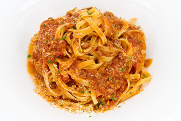 Traditional italian Tagliatelle pasta with Bolognese sauce in the blue plate with white background