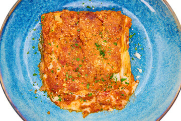 Traditional italian dish lasagna alla bolognese in the blue plate with white background