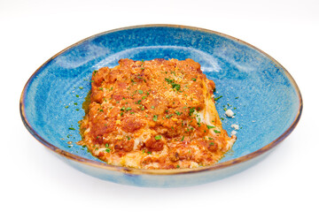 Traditional italian dish lasagna alla bolognese in the blue plate with white background