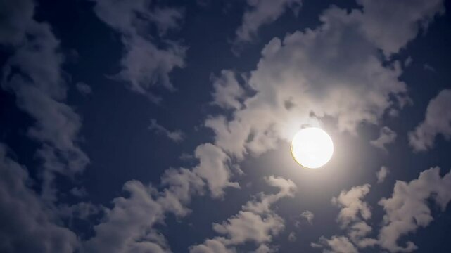 Majestic full moon journey amidst rolling clouds in night sky
