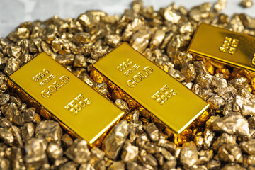 Gold nuggets and bars on table, closeup