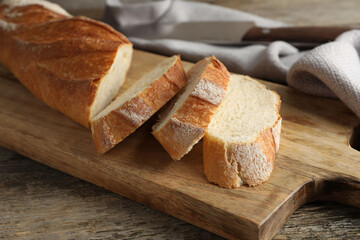Pieces of fresh baguette on wooden table, closeup