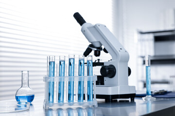 Chemical glassware and microscope on table in laboratory