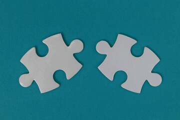 Obraz premium Two white puzzles with a blue background