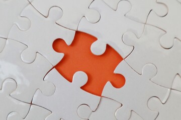 Incomplete white puzzles with an orange background