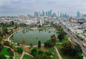 Naklejka premium MacArthur Park in Los Angeles, California, USA, offers a green space for recreation and relaxation amidst the urban landscape. The downtown skyline rises in the background.