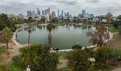Fototapeta premium Macarthur Park in Los Angeles, California, USA. A scenic view of the park's lake and the city skyline. People are enjoying the park's amenities, walking, and relaxing.