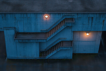 Moody exterior staircase with dim orange lights against a blue concrete wall, evoking a sense of solitude and urban mystery.