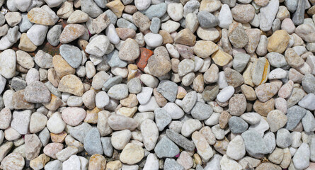 A variety of pebbles in different sizes, shapes, and colors, create a natural, textured background