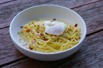 Creamy spaghetti carbonara served in a white bowl