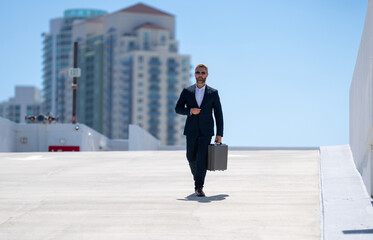 Rich businessman walking outdoors. Successful businessman with briefcase. Corporate leader on the move. Business man walking confidently. Businessman going to work. Handsome businessman in a suit.