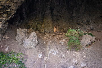 Bo Cave, part of Khao Iko in Phetchaburi, has a wide entrance, high chamber, stalactites, and skylights. Limestone cliffs rise at the front and back.