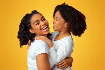 Cheerful Motherhood. Loving Black Woman Embracing With Her Little Daughter And Sincerely Laughing
