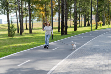 Caucasian woman roller skating with her jack russell terrier dog in park. 