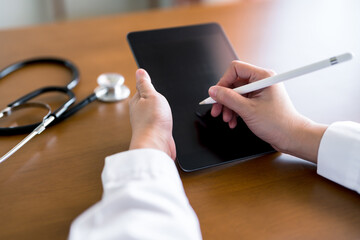 Close-up hands of doctor using stylus pen on digital tablet. Medical technology concept and...