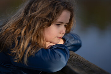 Childhood imagination. Outdoor portrait of a dreaming kid. Close-up of a child in deep thought....