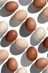 Natural eggs repeat pattern, beige brown colored Chicken egg with shadow at sunlight isolated on...