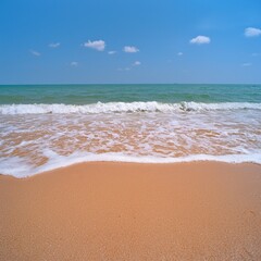 Serene Sandy Beach with Gentle Waves Under a Blue Sky