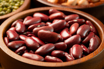 Raw red kidney beans in wooden bowl. Close-up
