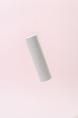 Floating White Cosmetic Bottle on Soft Pink Background