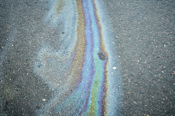 Colorful Oil Sheen on Pavement Creates Striking Visual Effect in Urban Environment.