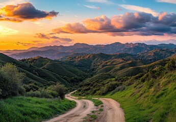 Scenic Landscape of Winding Dirt Road Through Lush Green Hills Under Colorful Sunset and Dramatic Clouds in Tranquil Natural Environment