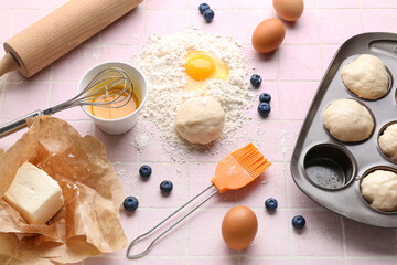 Composition with ingredients for preparing muffins on color tile background