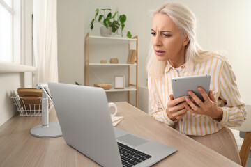 Mature woman video chatting with doctor at home