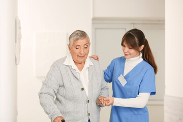 Fototapeta premium Senior woman with caregiver in hallway