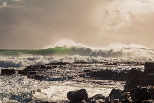 A moody, atmospheric photo of heavy surf and crashing breakers driven by an approaching cyclone or hurricane at Snapper Rocks on the Gold Coast on the East coast of Queensland, Australia.