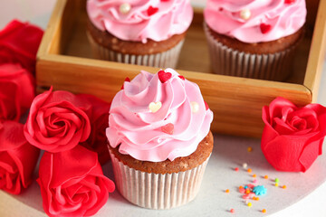 Tasty cupcake with rose flowers for Valentine's Day on white table