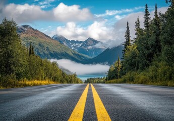 Serene Mountain Landscape with Two-Lane Road Leading to Lush Valley and Clouds under Blue Sky in Tranquil Wilderness
