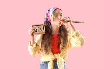Funny little girl with party blower and calendar on pink background. April Fools' Day celebration