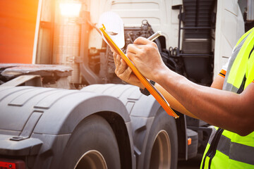 Truck Drivers Holding Clipboard to Check Truck Tires. Semi Truck Tractor, Big rig. Maintenance...