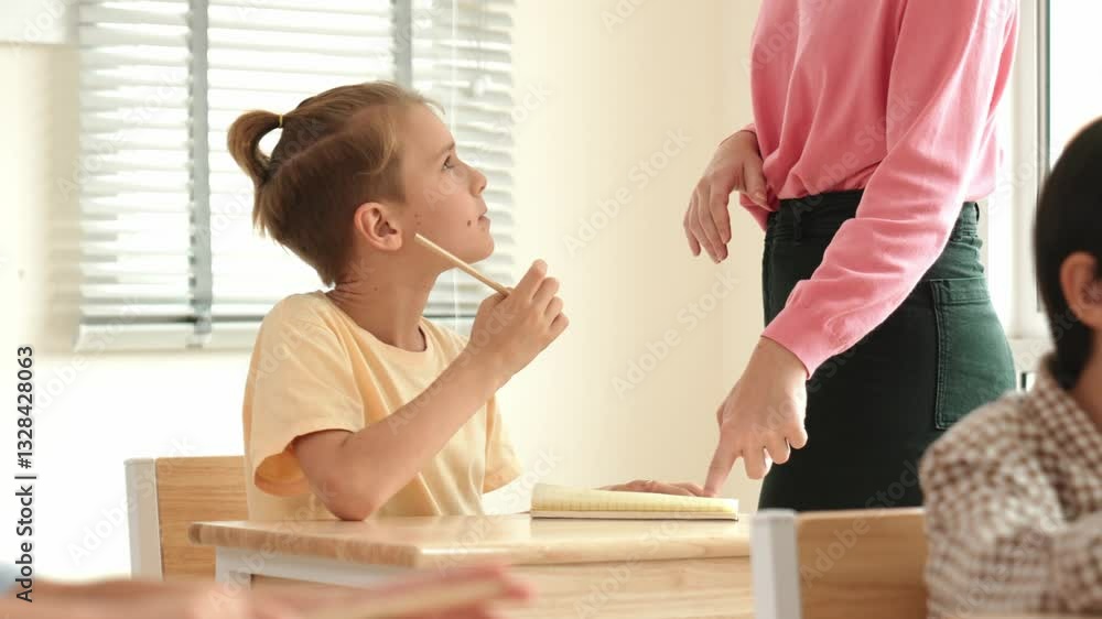 Poster beautiful teacher explaining test while caucasian boy doing classwork and listening explanation. cut